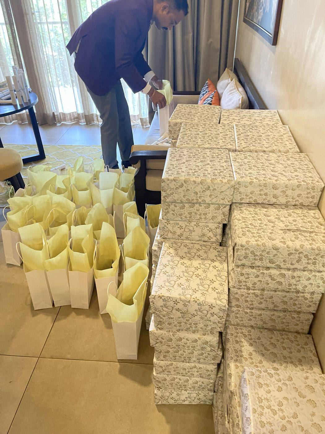 Our team packing welcome bags beside stacks of wrapped gifts, one for every guest