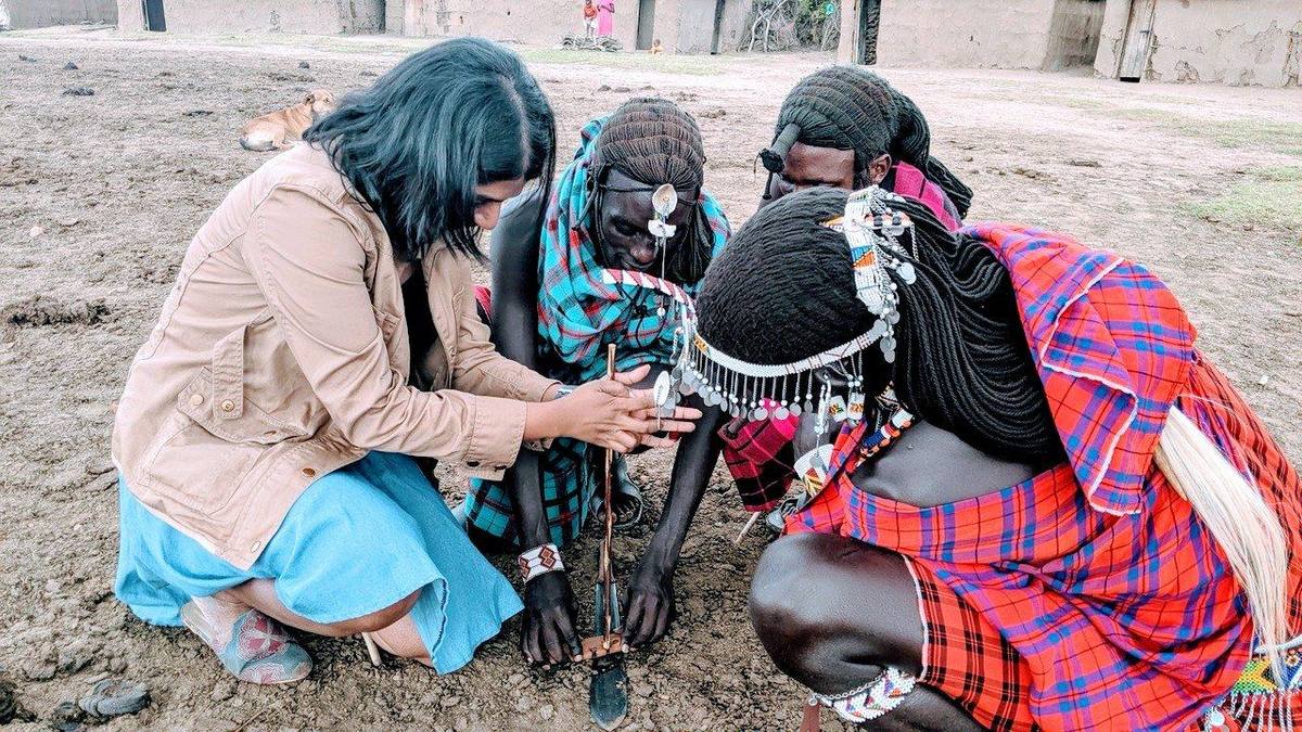 Learning to make fire with Maasai women in their village in Kenya